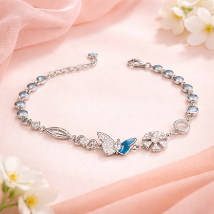 Silver bracelet with butterfly charm on a pink fabric background