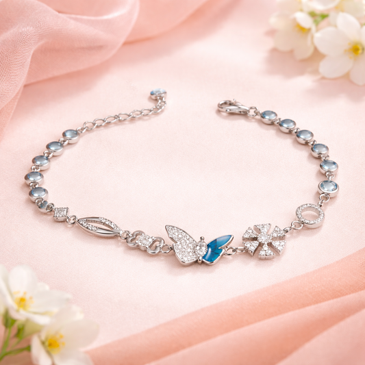 Silver bracelet with butterfly charm on a pink fabric background